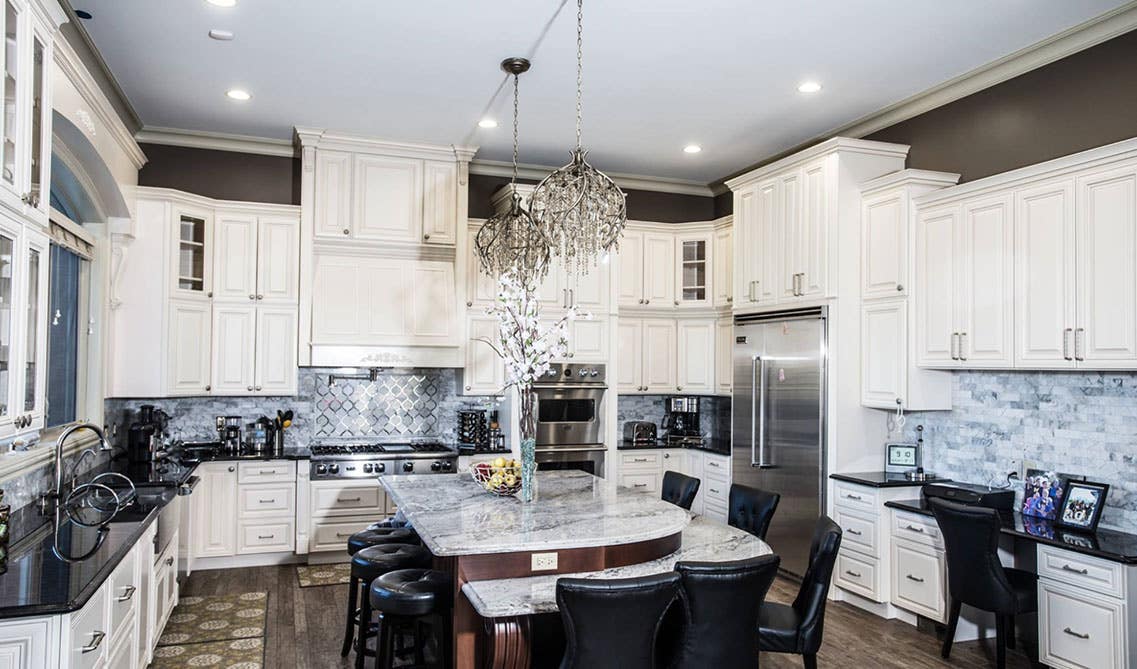 Traditional kitchen with white cabinets with black countertops 