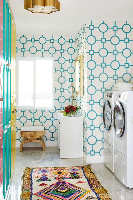Laundry room with fun wallpaper, Colorful Cabinets, washer and dryer, and rug