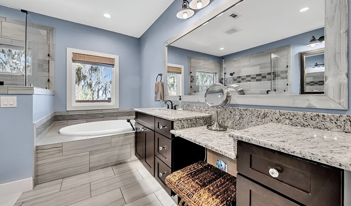 Shaker expresso bathroom vanity paired with granite countertop, blue wall and bath tub