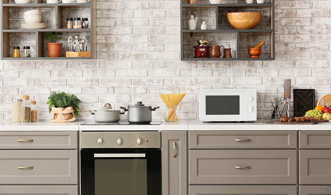 cut out design floating shelf with cutleries and gray base cabinets with white countertop