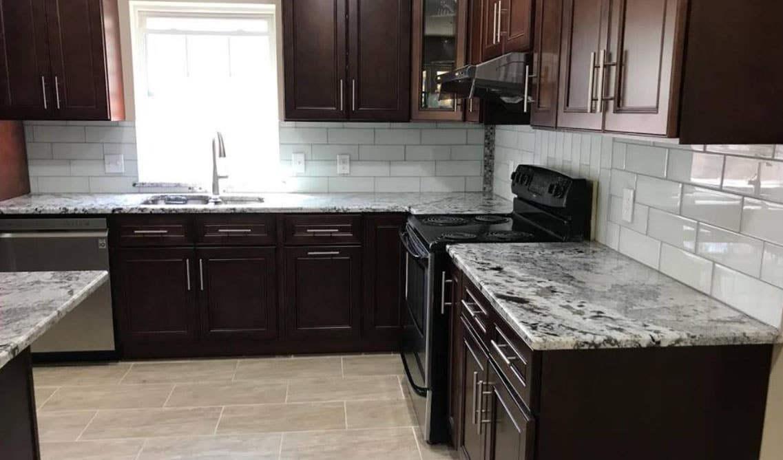 Dark cabinets with countertop and white subway tile backsplash 