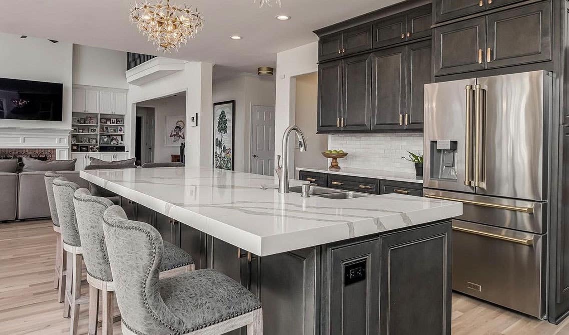 Open kitchen with dark gray driftwood kitchen cabinets, large island and stainless steel appliances 