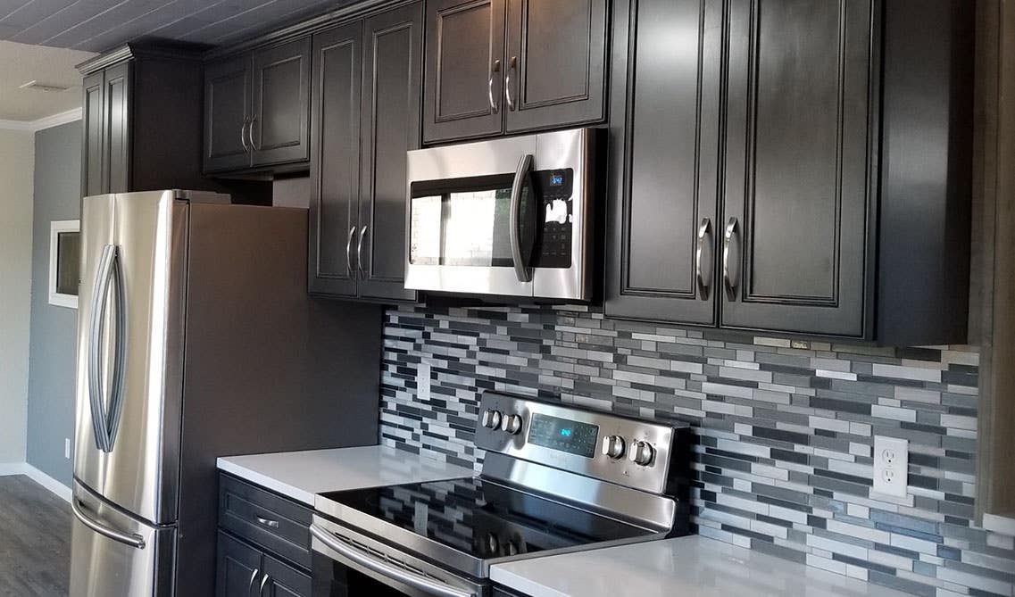 Dark kitchen cabinets with stone backsplash 