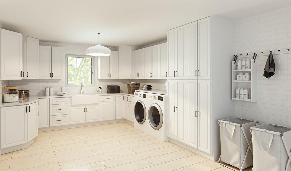 Full organized laundry room with white cabinets and decorative basket, tile flooring 