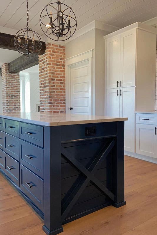 white wood cabinets with black handles and big countertop 