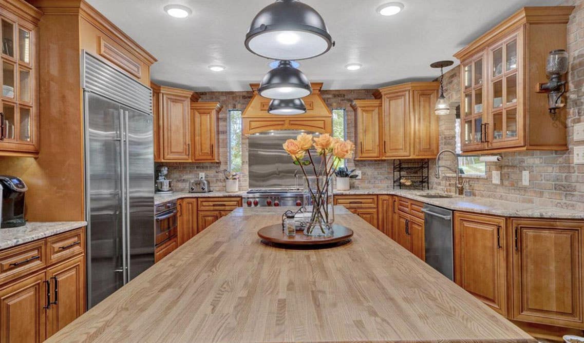 beautiful earthy tone kitchen with brown cabinets and large island with wood countertop