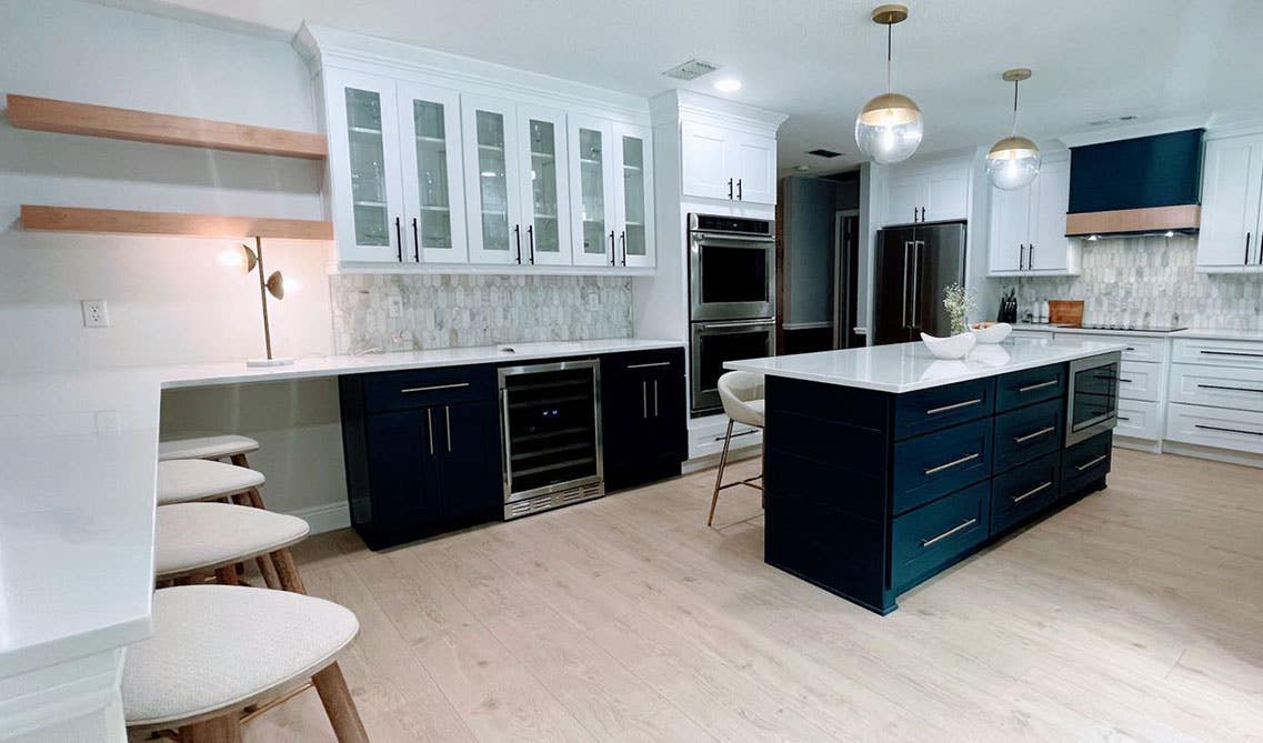 double island kitchen design with two toned kitchen cabinets with glass doors and pendant lights