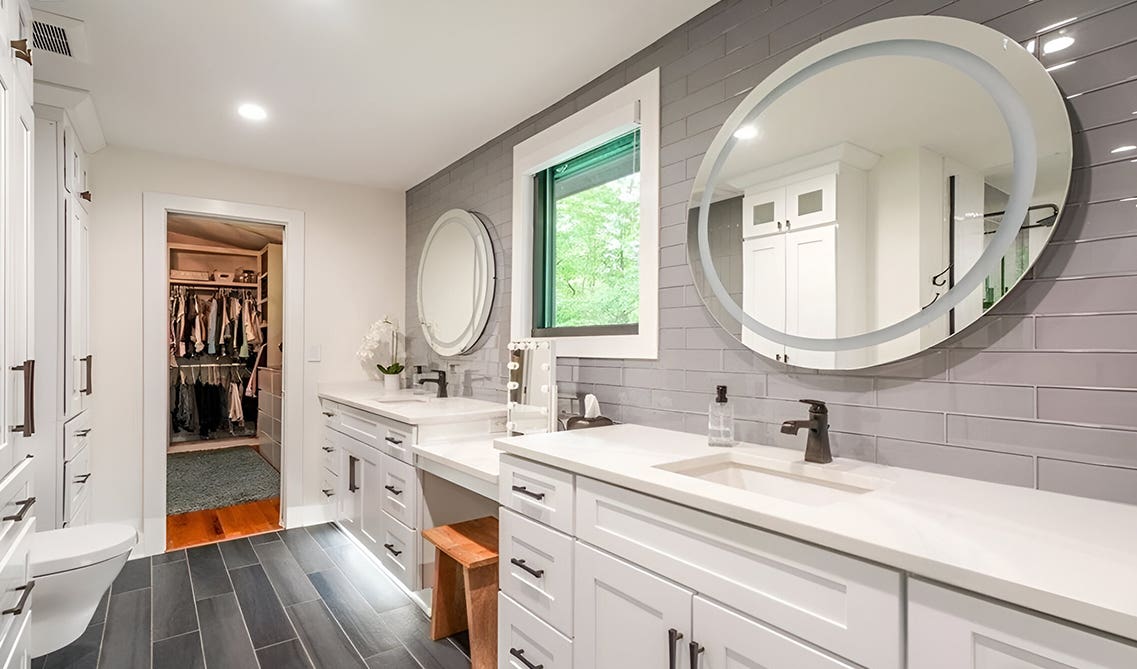 Double white vanity bathroom paired with matt black hardware and oval shape mirrors 