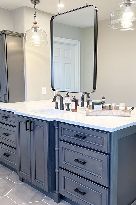 Driftwood Grey bathroom cabinets with bronze pull and free standing bathtub 