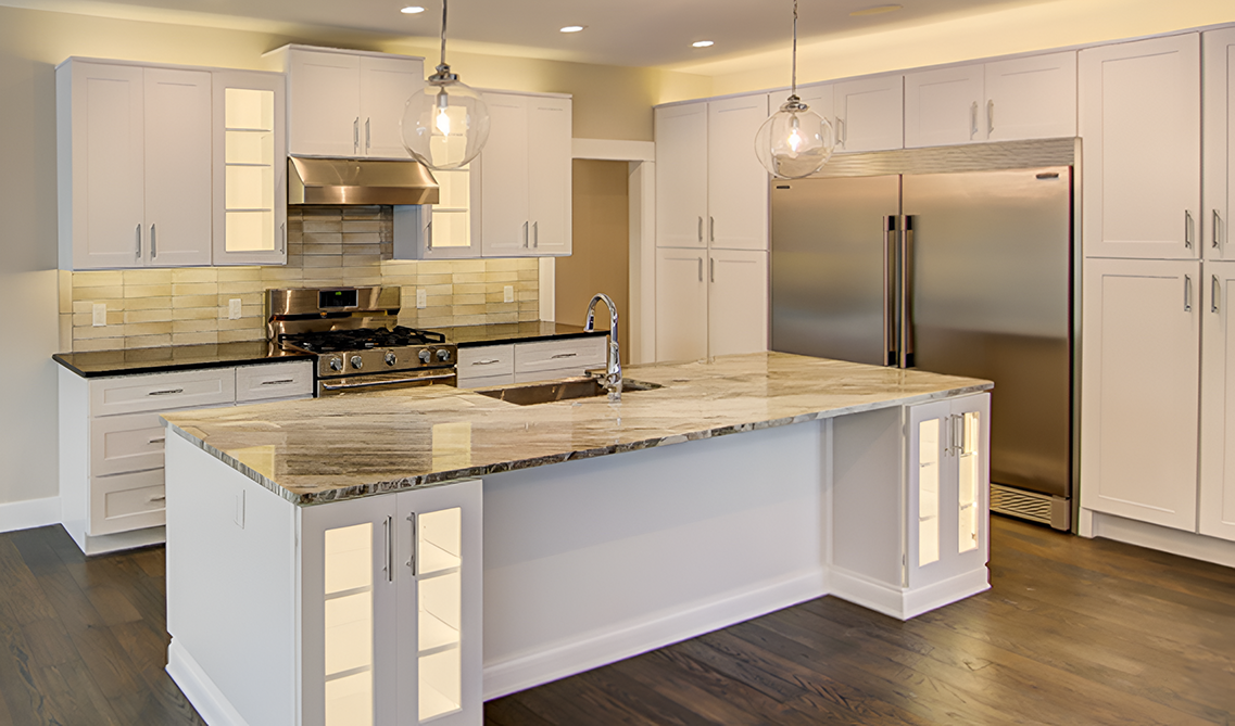 White shaker kitchen cabinets paired with marble countertop and stainless steel appliances 
