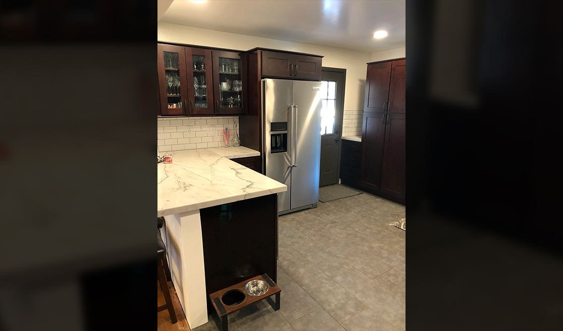 L-shaped kitchen features sleek espresso cabinets and a large matching peninsula 