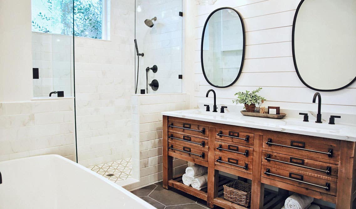 Farmhouse Style bathroom with rustic vanities, shiplap wall, vintage-inspired fixtures, 2 large round mirror