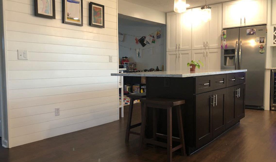 Farmhouse kitchen with white cabinets, Shiplap Wall and Small island