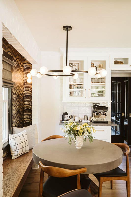 Farmhouse kitchen corner with white cabinets, and round sitting table