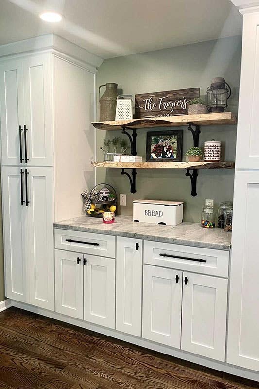 Farmhouse pantry cabinets with black hardware, floating shelves and art pieces