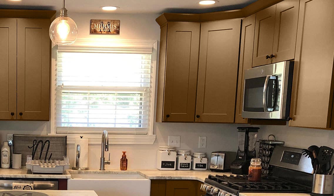 Traditional kitchen with dark cabinets, white marble countertop, and stainless steel appliances