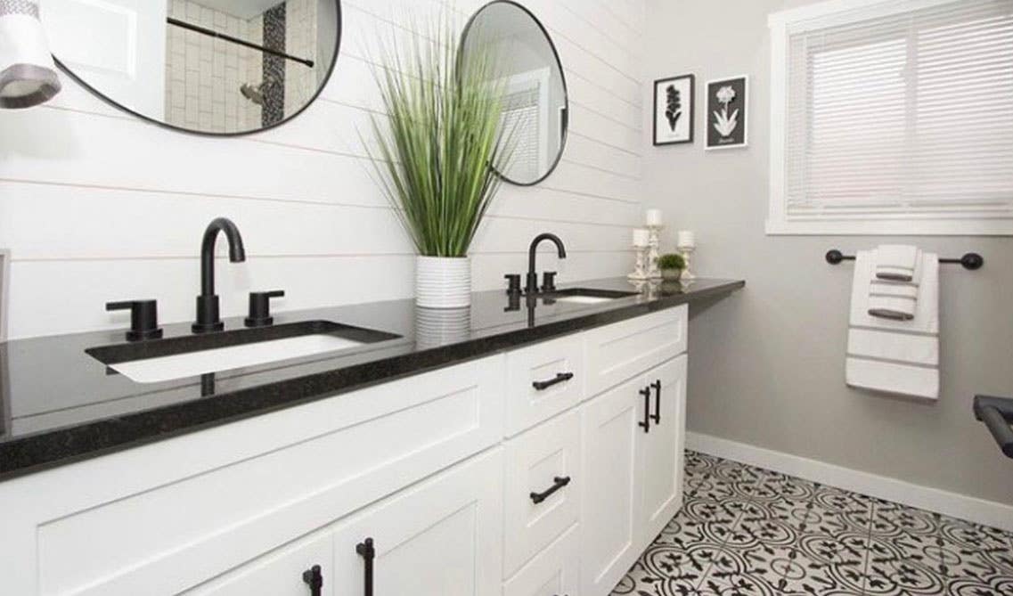 Farmhouse white bathroom with shaker vanity and black countertop 