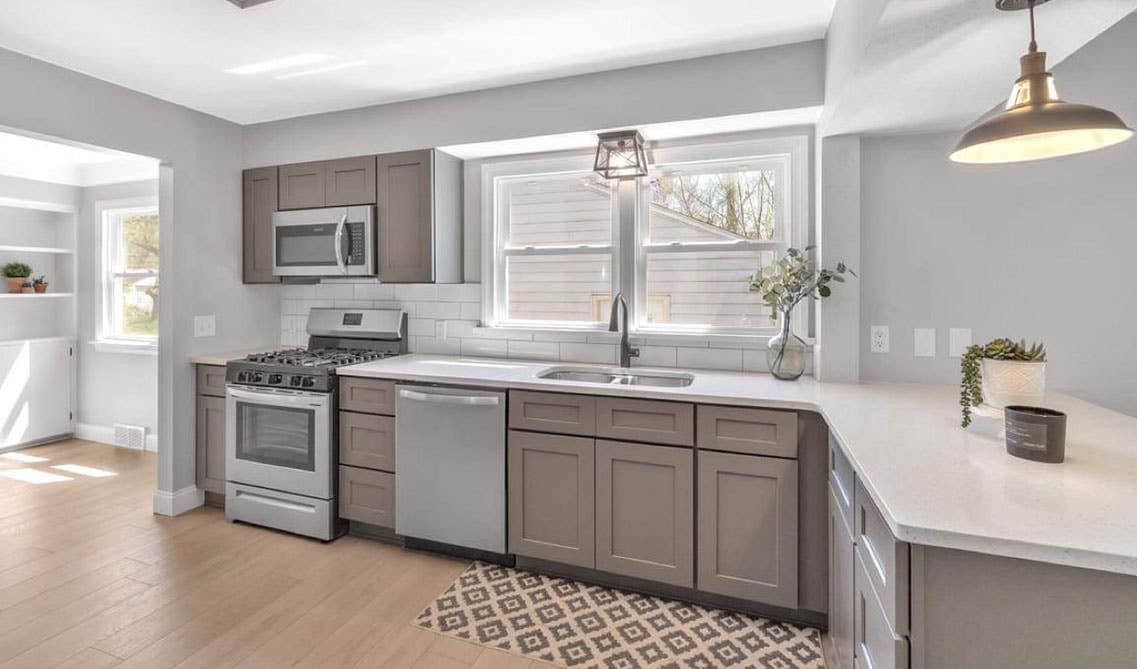 beautiful kitchen design with grey cabinets, hidden hardware, white countertop, double basin sink