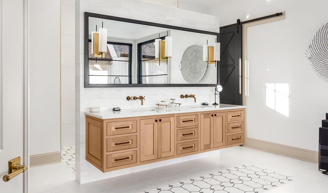 Bathroom design features floating wood vanity with white countertops, and double sink with one large mirror