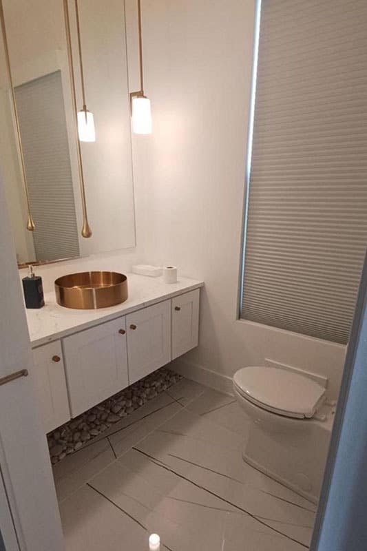 Aesthetics Powder Room Design with white floating vanity and Coper Accents fitting and fixtures