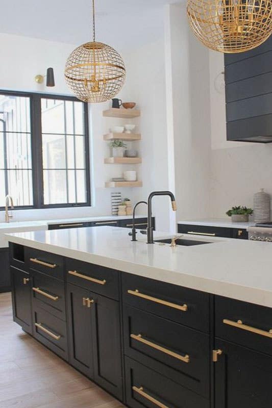 Dark wood cabinetry with lightly toned floors, and brass accents,