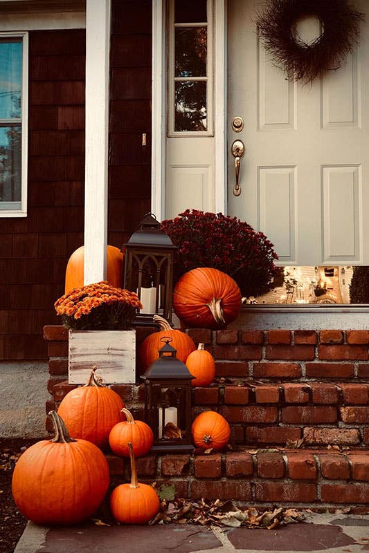 Front Stairs fall decor with potted mums, pumpkin luminaries and lanterns