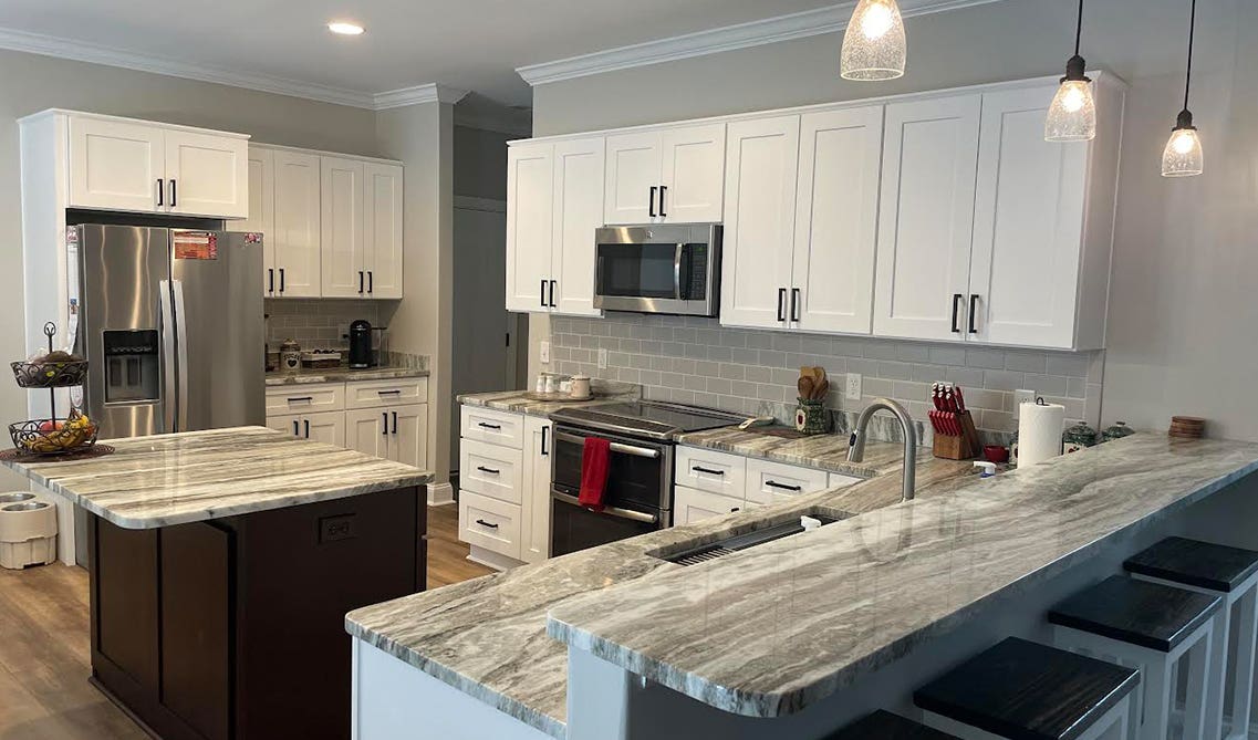 Full Grey granite countertop with white cabinets