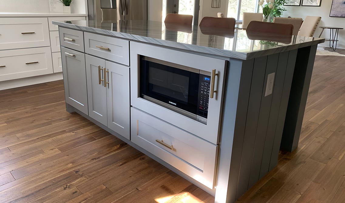 Functional kitchen island with hidden microwave compartment