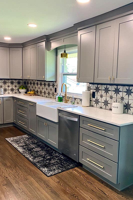 Gray shaker cabinets with white countertop, bold backsplash, SPC flooring