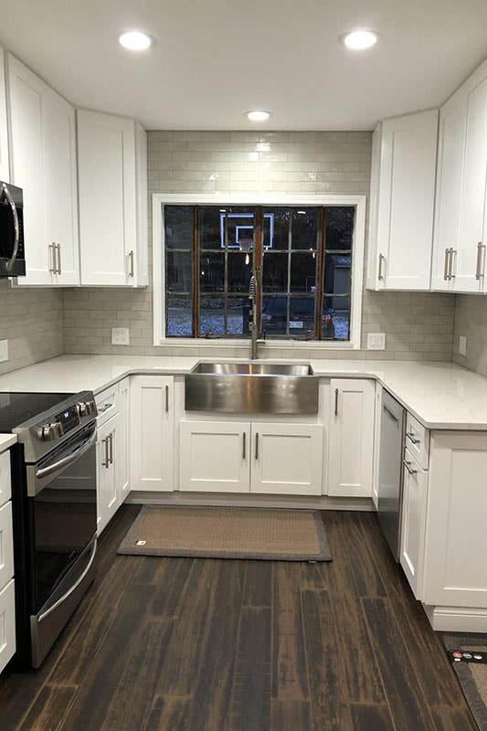 Kitchen with Galley layout with white shaker cabinets and farmhouse sink