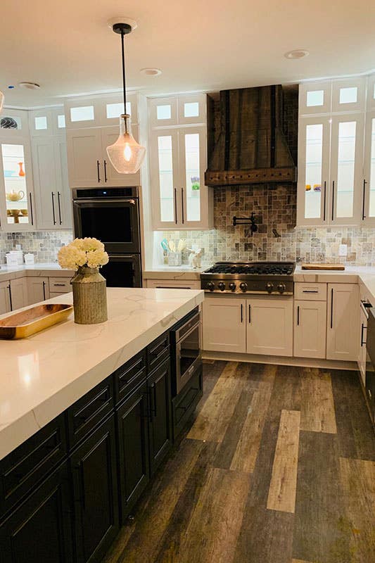 Glass Mosaic tiles paired with white cabinets, wood hood and marble countertop