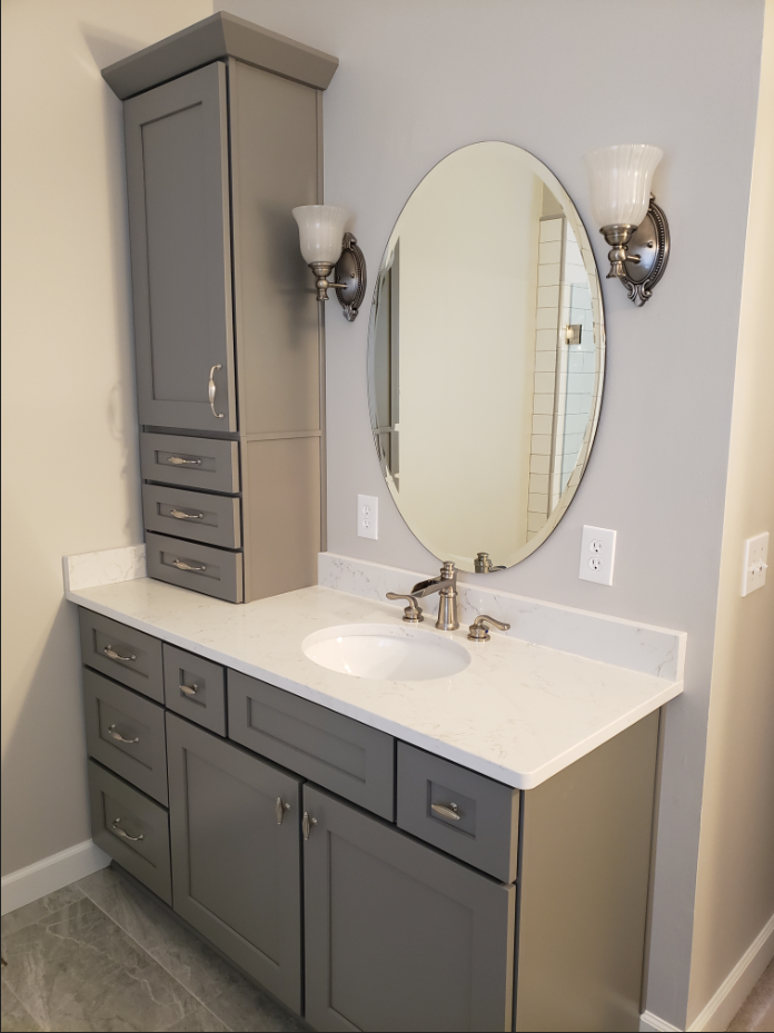 Bathroom features with grey cabinets with white countertops and ceramic basin 