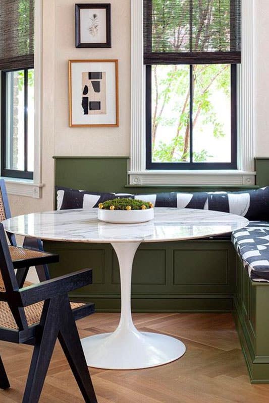 Dining corner with green sofa and white table, wood flooring