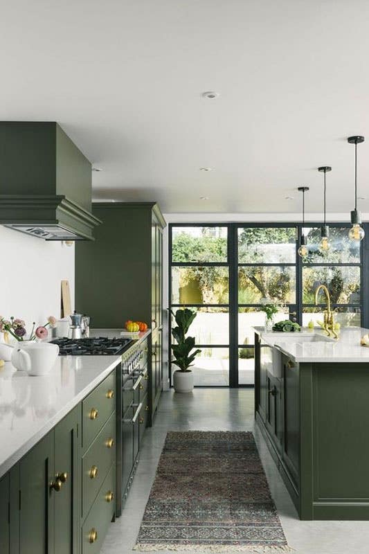 Modern kitchen features Green cabinets with matching green range hood