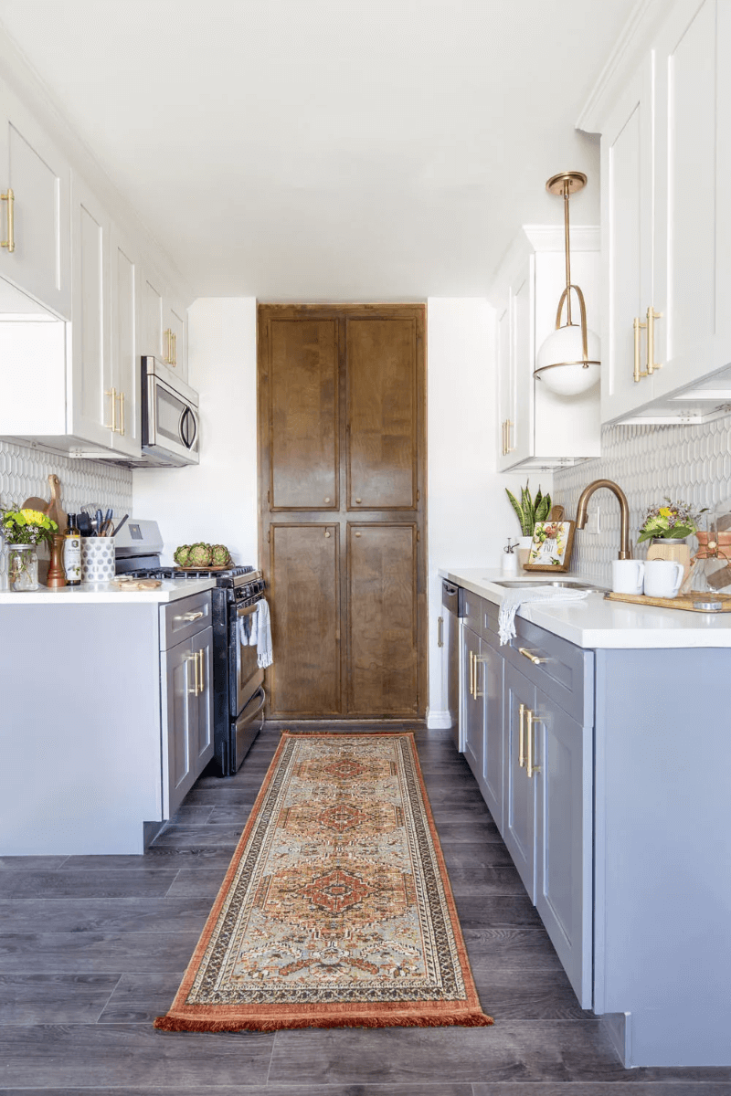 gray and white two-tone kitchen feature gold hardware and large rug