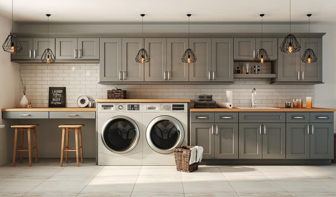 Laundry Room with gray cabinet, washer and dryer, and pendulum lights