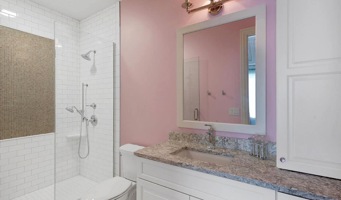 Bathroom design with Half Shower Wall, white vanity with dark countertop and toilet sheet