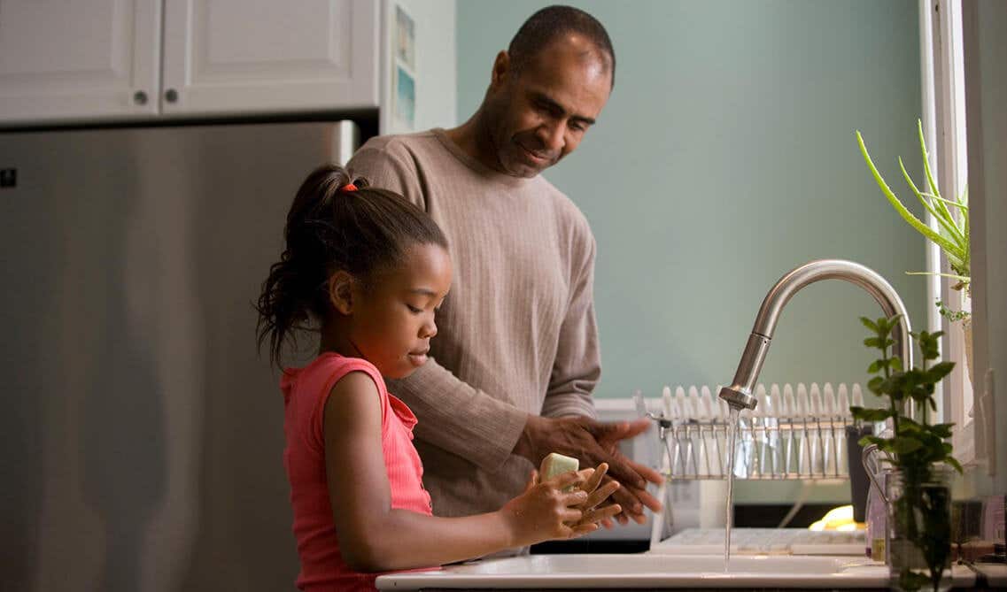 A man and kid whishing their hand in kitchen