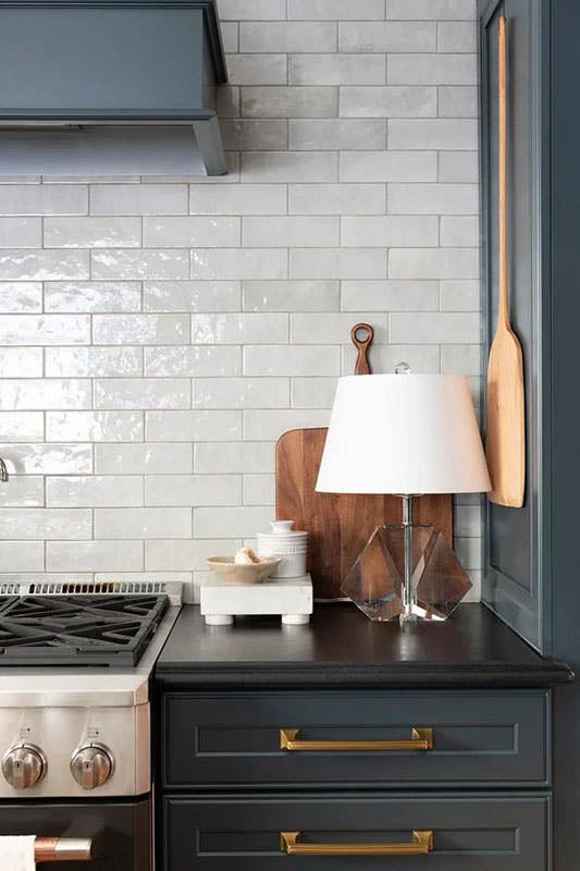 kitchen with dark cabinets, gold pulls, white subway tiles and Accent Lamps