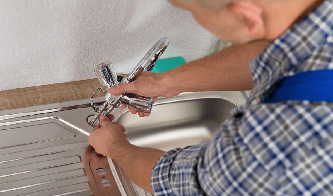 A man installing kitchen faucet 