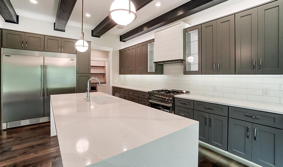 Dark gray kitchen cabinets with Fully Functional white Island and pendant light 