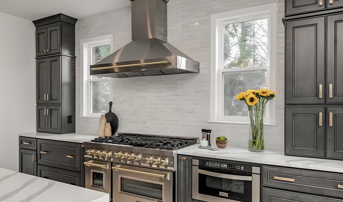 Driftwood gray kitchen cabinets paired with gold pulls and stainless steel appliances, 