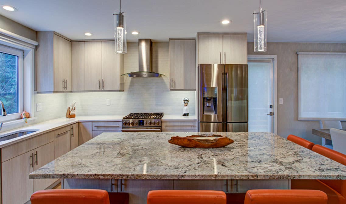 Kitchen Design with natural wood cabinets, large marble island, and stainless steel appliances 