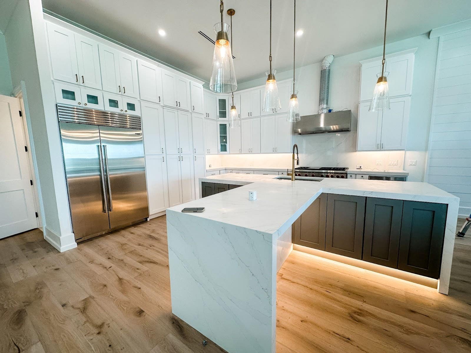 white kitchen cabinets, large island with storage cabinets and undermount sink