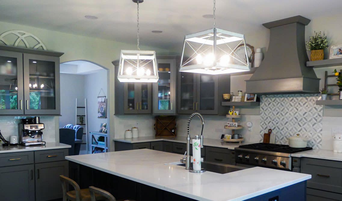 Traditional kitchen design with gray cabinets and pendent lights