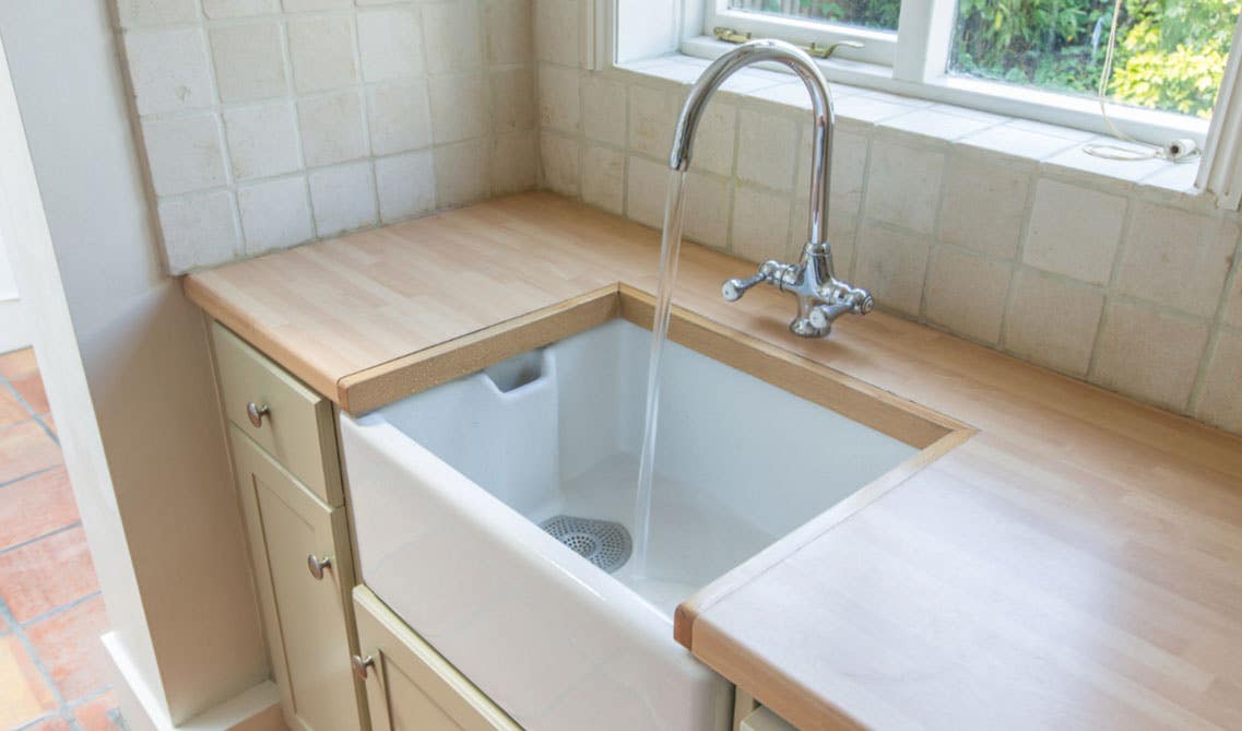 White ceramic kitchen sink with wooden countertop 