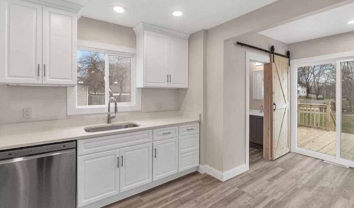 Kitchen with white cabinets, countertop with single bowl sink, and spc flooring