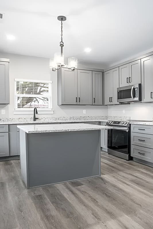 Gray shaker elite kitchen cabinets paired with small island, Granite Countertop and stainless steel appliances 