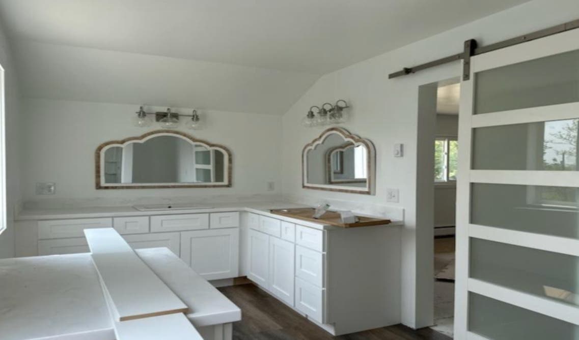 L shape bathroom design with white vanity and statement mirror