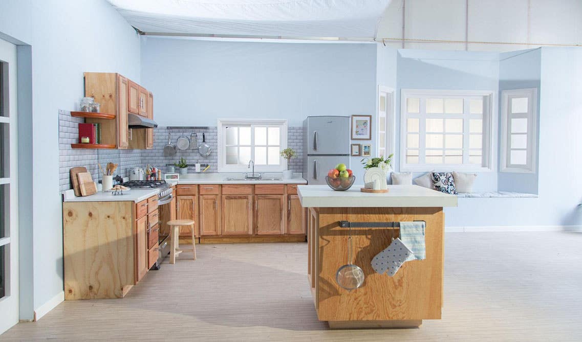 L shape kitchen with oak cabinets, white countertop, Silver handles and knobs and Subway tiles backsplash